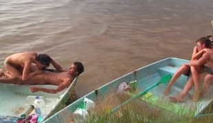 Lustful people are having group sex on the beach in a small boat